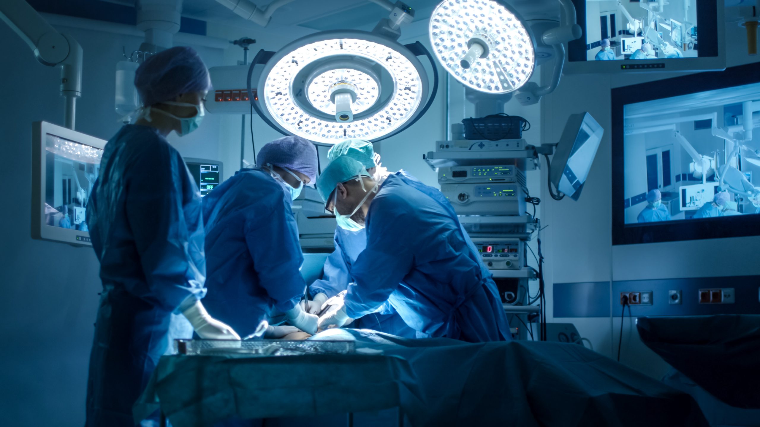 doctors in an operating room working on a patient